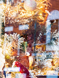 圣诞节和新年装饰品 由稻草 灯泡和假雪制成的鹿反射照明松树庆典动物窗户枞树玩具假期背景图片