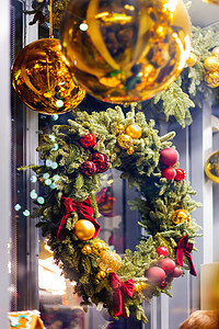 圣诞花圈由鲜树枝制成 有红色和金色的丝带 球和弓 闪亮的新年装饰图片