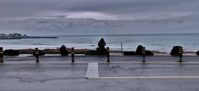 一位独自一人坐在南朝鲜济州岛海滩上的女人图片