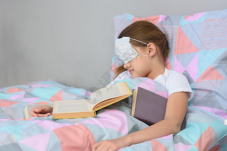 生病的女孩躺在床上睡着 把面罩拉在脸上图片