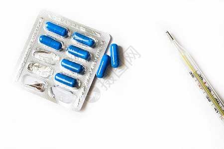 白色背景的一包药片和温度计处方玻璃医生药剂宏观胶囊剂量吸塑包装药丸图片