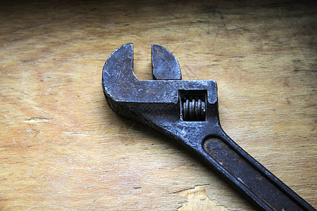 木制背景上的铁可调整扳手桌子合金工具黑色金属维修管道技术活动钥匙图片