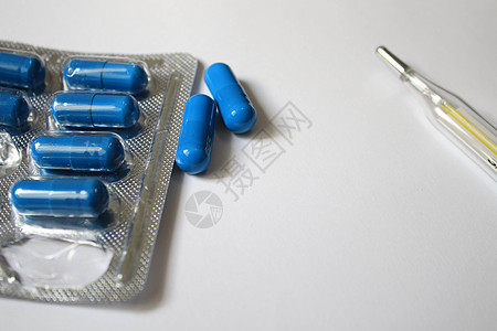 白色背景的一包药片和温度计吸塑水疱疾病玻璃医院治愈蓝色医生帮助制药图片