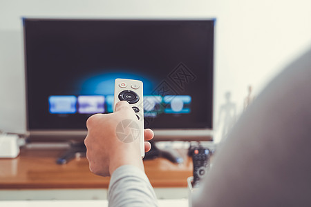 一个女人手拿着客厅电视盒的遥控器电视视频电子技术电影手指屏幕控制娱乐互联网图片