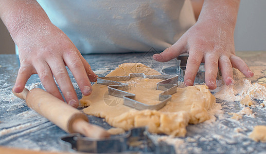 女孩做曲奇饼干 与一个面粉厨房食物烘烤厨师糕点面团围裙快乐甜点图片