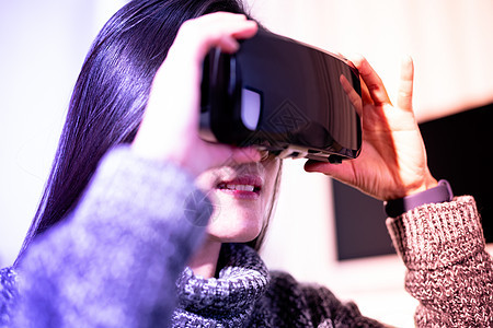 戴着虚拟现实眼镜的女人 与 V 一起使用的智能手机展示成人微笑创新商业娱乐耳机高科技技术享受图片