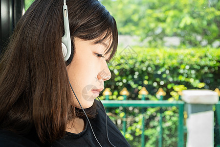 女孩从数字平板电脑上听音乐闲暇女性说谎娱乐学习青少年耳机音乐技术药片图片