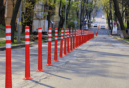 旧公路沥青覆盖率低 在阳光照耀的市区街道上被红路柱分割图片