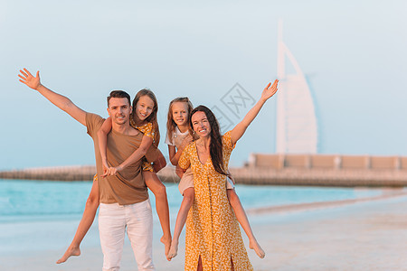 暑假在沙滩上快乐的一家人海洋女儿酒店乐趣海滨假期微笑海岸线男人海滩图片