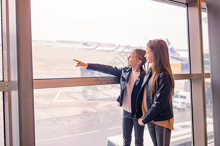 机场的小孩在等登机行李旅游乘客护照游客女儿窗户运输航空公司斗争图片