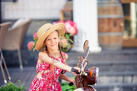 穿着帽子的可爱小女孩 在脚踏车室露天生活驾驶街道发动机乐趣运输享受司机旅行幸福图片