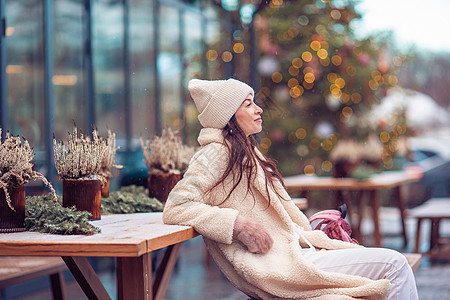 新的一年 在雪地的firtree树枝附近的快乐女孩新年咖啡店地标假期市场微笑孩子季节手套城市图片