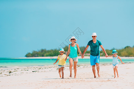 度假的年轻家庭玩得很开心海岸线假期男人海洋孩子父母童年乐趣爸爸母亲图片