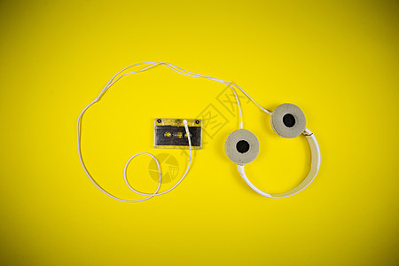 黄色背景的录音带磁带和现代耳机体积白色电脑立体声技术配饰黑色进步光盘麦克风图片