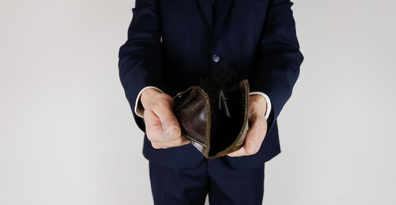 一个身着商业西装的男人 手里拿着一个空钱包破产经济金融股票商务悲哀企业失业人士贫困图片