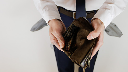 一个身着商业西装的男人 手里拿着一个空钱包失业失败友谊金融危机贫困危机债务人士企业男性图片