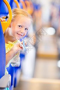可爱的小女孩乘火车旅行 与飞机型号一起玩乐在手孩子享受微笑女儿游客过境交通假期运输女性图片