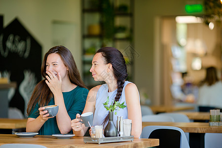 快乐笑容的年轻女子在咖啡馆喝咖啡 交流和友谊概念青少年闲暇假期女性女朋友咖啡店谣言朋友城市耳语图片