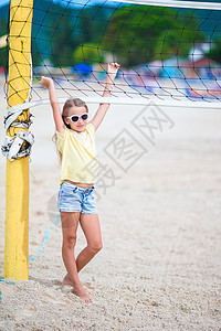 小可爱女孩玩沙滩排球打球 运动家庭喜欢在户外玩海滩游戏图片