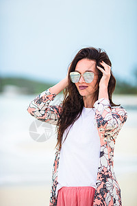 白色沙沙热带海滩上的年轻美女 日落时的高加索女孩幸福太阳镜蓝色女性奢华太阳海洋假期休息晴天图片