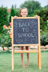 快乐的小女学生 在户外用黑纸板玻璃一年级教育女学生幼儿园课堂小学生童年班级女孩图片