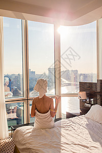 头戴白色浴巾的漂亮年轻女子在床上淋浴后放松 喝杯咖啡假期窗帘毛巾窗户闲暇女性卫生身体卧室皮肤图片