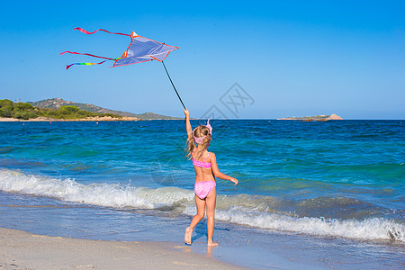 在热带海滩玩风筝的小女孩 快乐的小姑娘喜悦海岸活力海岸线天空跑步女性支撑海浪童年图片