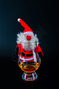 圣诞老人与单一麦芽威士忌玻璃杯圣诞节的象征快乐庆典幸福饮料帽子烈酒玻璃喜悦乐趣假期图片