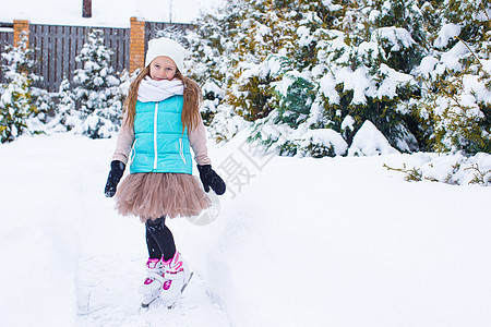 可爱的小女孩在寒冬雪日露天户外溜冰冰鞋天气孩子运动数字季节喜悦女儿童年手套图片