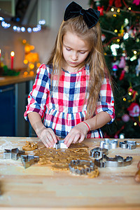 小女孩在家厨房为圣诞节做烤姜饼饼干的圣诞小姑娘帮助手工季节滚动家庭糖果女孩糕点假期桌子图片