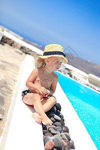 在圣桑托里尼希腊度假期间 在游泳池附近的可爱小女孩海景女儿热带旅游晴天女士海岸海岸线童年享受图片