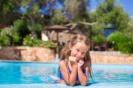 可爱快乐的小女孩 在游泳池玩得开心游泳童年乐趣相机微笑女孩喜悦休息娱乐闲暇图片