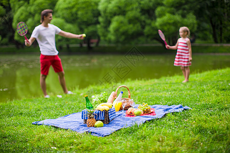 家庭在公园野餐快乐游戏假期自由婴儿球拍父亲爸爸羽毛球孩子活动图片