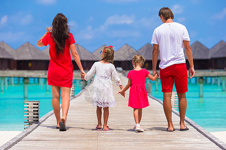 在豪华度假度假胜地暑假期间 美人家庭在木制码头的背面景色图片