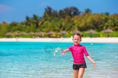 暑假期间海滩上可爱的小女孩在沙滩上海岸幸福热带享受支撑婴儿女孩假期蓝色闲暇图片