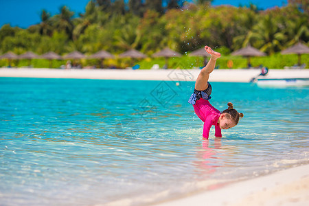 沙滩度假时可爱的小女孩玩得开心快乐异国女儿海滩海岸热带闲暇微笑手提箱婴儿图片