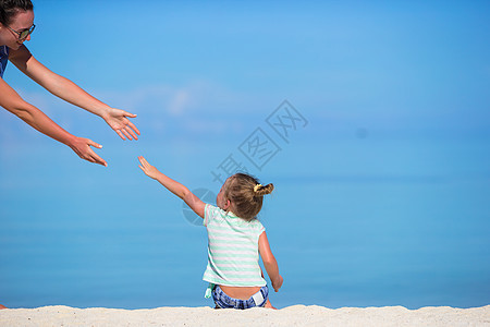 暑假期间海滩上可爱的小女孩在沙滩上闲暇情调太阳镜微笑孩子喜悦幸福乐趣异国假期图片