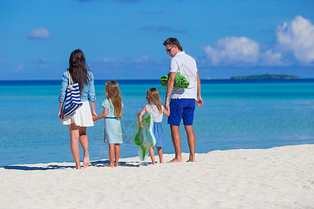 四岁四岁的年轻家庭在沙滩度假女儿海滨孩子们父母女性阳光孩子父亲享受姐姐图片
