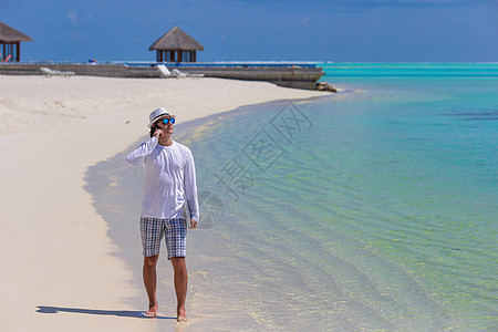 白沙滩上带电脑和手机的年轻人男人成人旅行飞机场互联网游客海洋技术生意人商业图片