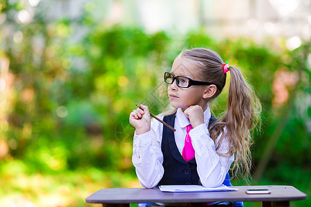 可爱的小女孩在书桌外放纸条和铅笔 回学校去幼儿园教育女性乐趣学习小学生假期童年一年级孩子图片