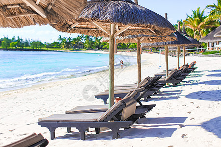 在美丽的热带海滩上坐椅子和伞子 白沙 奇异岛的绿绿海等白色沙滩图片