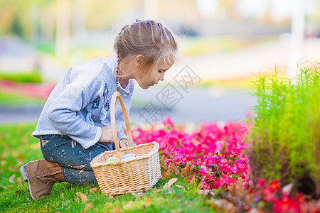 可爱的小女孩 在户外寻找复活节鸡蛋孩子兔子篮子幸福花园传统享受季节公园女孩图片