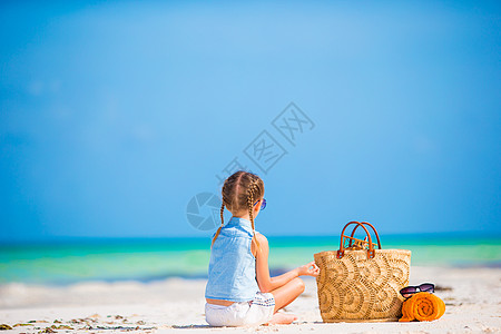 在暑假期间带沙滩袋和毛巾的可爱小女孩旅行热带孩子玩具海滩快乐海岸线异国乐趣喜悦图片