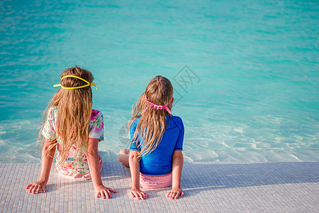 暑假时在游泳池游泳的可爱小女生孩子海滨天堂童年海洋享受眼镜女儿太阳泳装图片