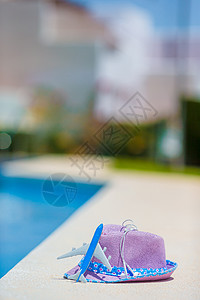夏季在游泳池附近靠近游泳池的飞机模型和紫色草帽海洋游泳配饰防晒霜果汁条纹异国热带蓝色支撑图片