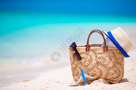 海滩配饰  沙滩上的草包 耳机 玩具飞机和太阳镜热带娱乐帽子异国假期旅行海岸线旅游支撑享受图片