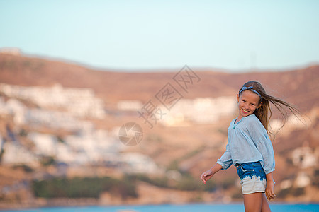 在希腊海滩度假的可爱快乐微笑的小女孩图片