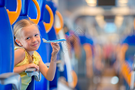 可爱的小女孩乘火车旅行 与飞机型号一起玩乐在手游客女性童年活动交通女孩铁路车站风景女儿图片