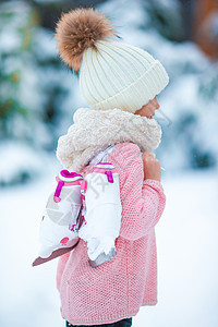 可爱的小女孩在寒冬雪天去户外滑冰孩子们乐趣女性溜冰场季节枞树女学生活动童年假期图片