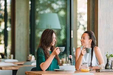 快乐笑容的年轻女子在咖啡馆喝咖啡 交流和友谊概念女朋友咖啡店杯子谣言女孩街道青少年城市女士朋友图片